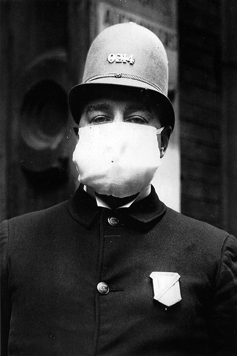 A New York City police officer wears a flu mask while on duty, October 7, 1918.