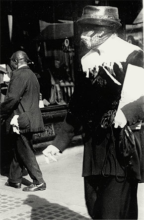 A New York City resident wears a homemade flu mask while out shopping, October 1918.