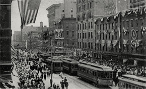 The busy intersection of South Salina and Washington Streets in downtown Syracuse. The E. W. Edwards department store can be seen on the right. Today, the site is home to Perseverance Park.