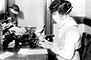 A New York City typist wears a flu mask while at her desk, October 16, 1918.