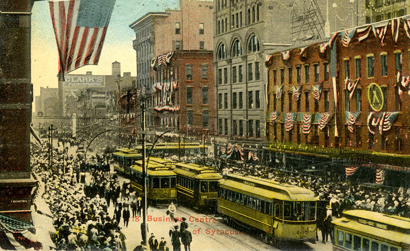 The busy intersection of South Salina and Washington Streets in downtown Syracuse. The E. W. Edwards department store can be seen on the right. Today, the site is home to Perseverance Park.