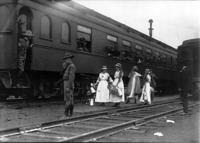 Men on troop train, with Red Cross workers in front. Scenes like this were common throughout the war period and during the epidemic.
