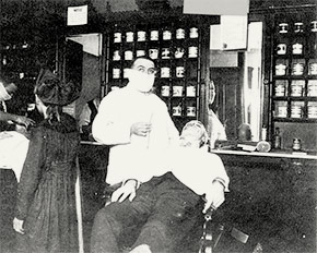 A Cincinnati barber wears a mask while giving a customer a shave.